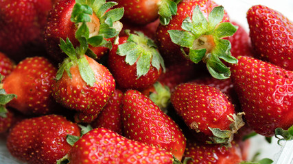 Freshly picked strawberries from the home garden. Natural organic food production. Heap of summer red berries. Homegrown, gardening and agriculture concept. Close up. Soft focus