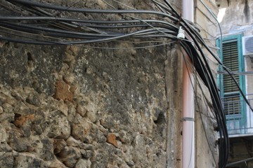 evocative image of water pipes and electric current wires positioned on the facade of an 
ancient...