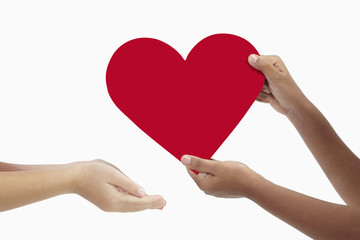 Girl giving a big cut out heart to her friend