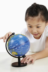 Girl looking at globe on the table