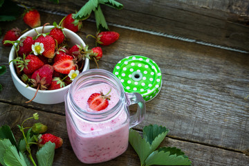 Natural detox, fruit dessert, healthy dieting concept. Strawberry fruit Yogurt smoothie or milk shake on a rustic wooden table. Copy space.