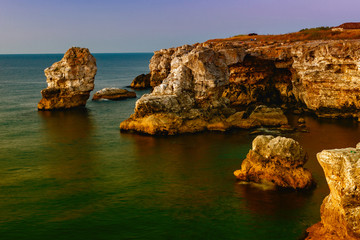 Fototapeta na wymiar sunrise at the calm sea and the rocks on which we relax