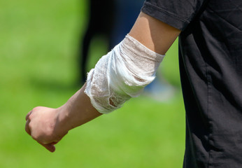 A wounded man’s arm wrapped in a bandage
