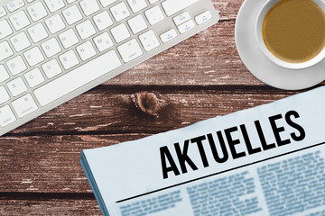 Ein Bürotisch und Zeitung mit dem Titel Aktuelles
