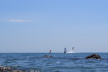 Naklejka premium Walk on the sea on a board with a sail. Flying on a water jet.