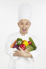 Asian chef with an armful of vegetables