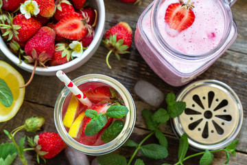Healthy dieting concept. Lemonade with fresh strawberries and Strawberry fruit Yogurt smoothie or milk shake on a rustic wooden table. Top view flat lay background.