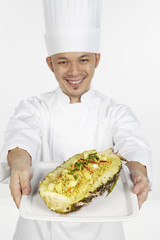 Asian chef with a plate of Thai pineapple fried rice