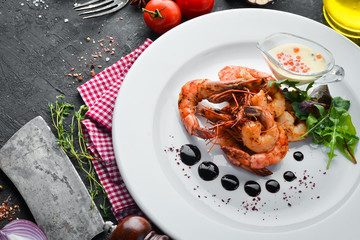 Grilled shrimps with sauce on a plate. Top view. Free copy space.