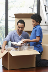 Man and boy packing box together