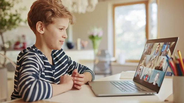 Cute Little Boy Uses Laptop with Conference Video Call Software to Talk with Group of Relatives and Friends