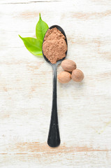 Nutmeg in spoon. Indian spices. Top view.