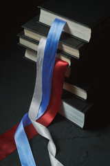 Russian flag and constitution. Conceptual photo where the arrangement of books in a stack affects the order of the tapes 