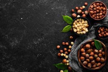 Obraz na płótnie Canvas Hazelnuts in a bowl on a black stone background. Nut. free space for your text. Top view.
