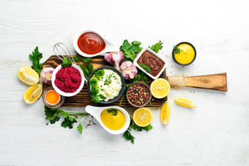 Set of sauces and spices on white wooden background. Top view.