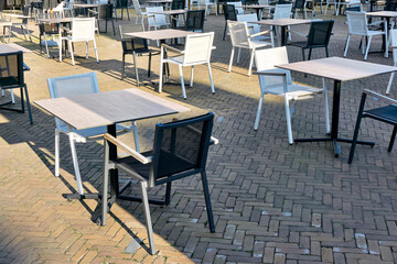 Empty terrace of a closed restaurant in The Netherlands with plenty of space between tables and chairs during coronavirus restrictions waiting to reopen. Social distancing concept.  