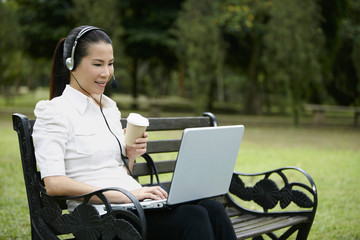 Mid adult businesswoman having a conference call while eating