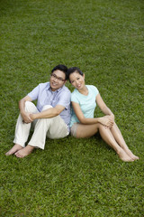 Man and woman sitting on field