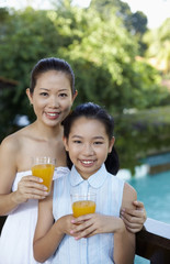 Mother and daughter with glasses of orange juice