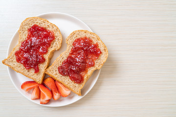 whole wheat bread with strawberry jam and fresh strawberry