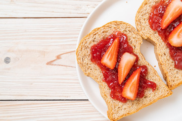 whole wheat bread with strawberry jam and fresh strawberry