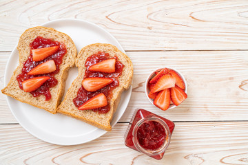 whole wheat bread with strawberry jam and fresh strawberry
