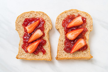 whole wheat bread with strawberry jam and fresh strawberry