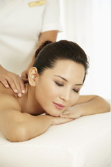 Obraz na płótnie Canvas Woman lying forward on massage table with her eyes closed
