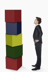 Businessman looking at a stack of cubes