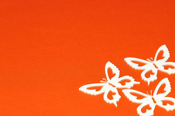 White butterflies on an orange background, a creative minimal concept, copy space.