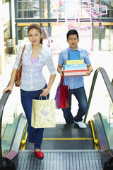 Woman walking while man carry shopping items