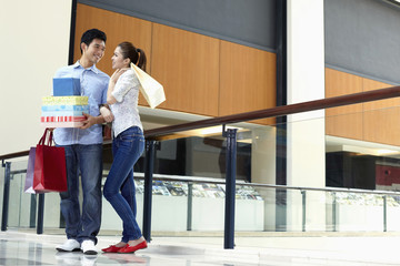 Obraz premium Man helping woman carry shopping items