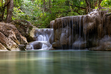 Fototapeta na wymiar Beautiful waterfall with still emerald green water in Erawan National Parik in Kanchanaburi