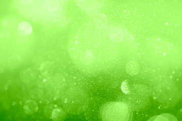 Fototapeta na wymiar Glittery bokeh pattern on a green background