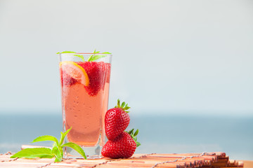Just made fresh strawberry cocktail with mint and lime, refreshment on summer. Mojito drink on a seaside on vacation.