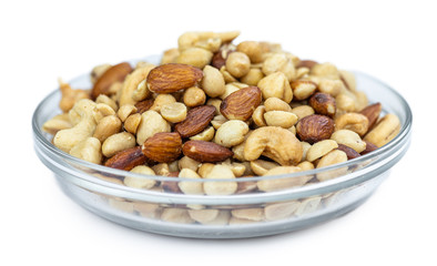 Portion of roasted nuts isolated on white (close up; selective focus)