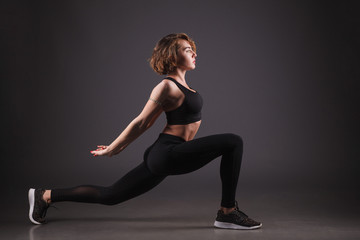 Fototapeta na wymiar Young girl doing yoga on a black background