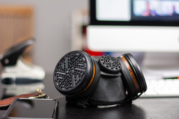 Protective half-mask  laying on an office desk with a computer in the background