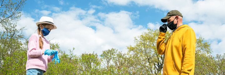 pensioner and schoolgirl stand at safe distance by trees