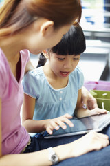 Mother and daughter using digital tablet