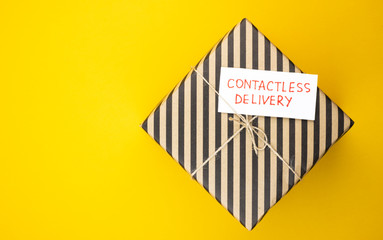 The box is delivered by contactless delivery on an orange background. the package is ordered online during the global covid-19 coronavirus pandemic. food delivery to your home