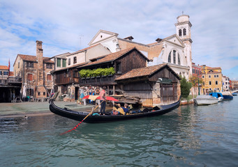 Obraz premium Gondola with tourist near Gondolas Repair Yard in Venice.