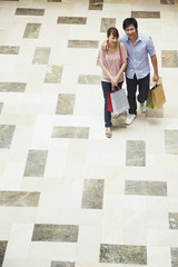 Man and woman walking and carrying shopping items