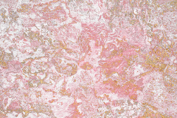 Grunge gold glitter on a pink textured background