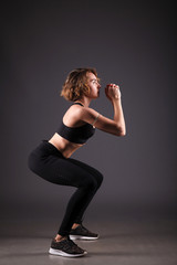 Young girl doing yoga on a black background