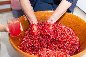 Manos de mujer mezclan la sangre de cerdo con el resto de los ingredientes de una morcilla de arroz...