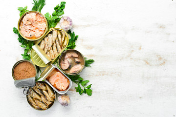 Canned fish in tin cans: Salmon, tuna, mackerel and sprats. Top view. Free space for your text.