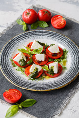 Classic caprese salad. Served with tomatoes, mozzarella, arugula, basil and pesto.