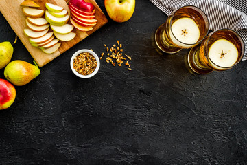Glasses of beer with apple and peer on black table top view copy space