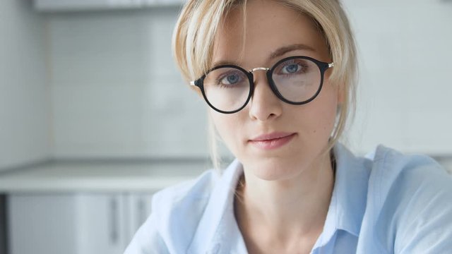 Woman in eyeglasses seriously looking into camera, female health problems, pms